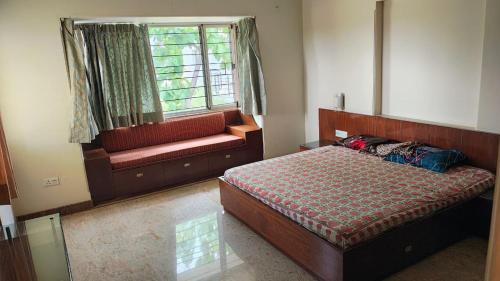 a bedroom with a bed and a window and a couch at vaibhav farm house in Govindgarh Malkpur