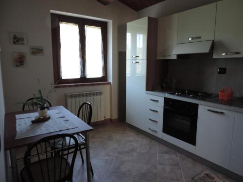 a kitchen with a small table and a kitchen with a stove at Il Gelso Rosso in Comunanza