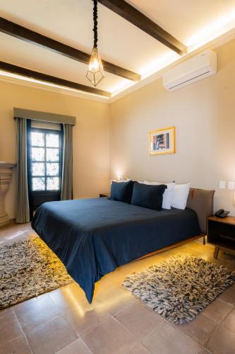 a bedroom with a large blue bed with a window at Casa Studio San Miguel de Allende in San Miguel de Allende