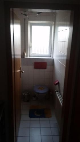 a small bathroom with a toilet and a window at HomeStay Sandra in Hockenheim