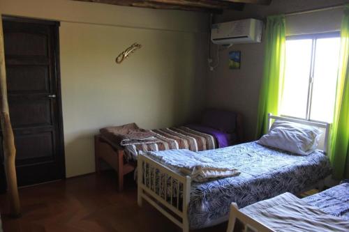 a room with two beds and a window at Manantial in Guaymallen