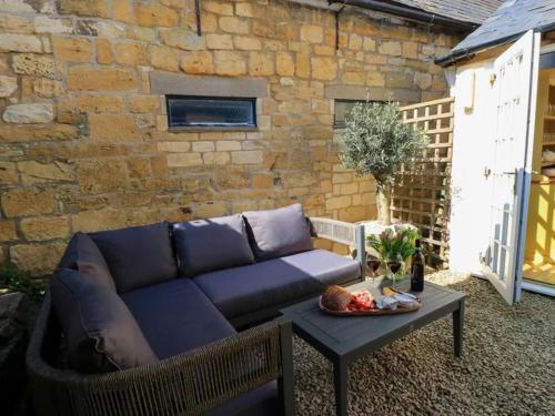 a blue couch and a table in front of a brick wall at Bay House in Broadway