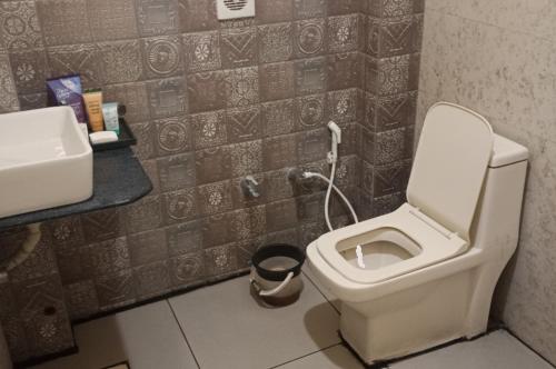 a bathroom with a toilet and a sink at Hotel Radhika in Somnath