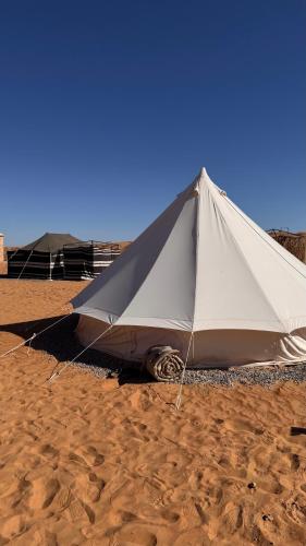 une grande tente posée sur le sable de la plage dans l'établissement Majicdunes, à Al Raka