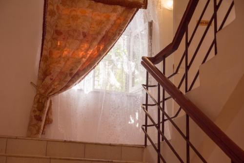 a staircase with a curtain and a window at Andron Hotel on Ilyicha Square in Moscow
