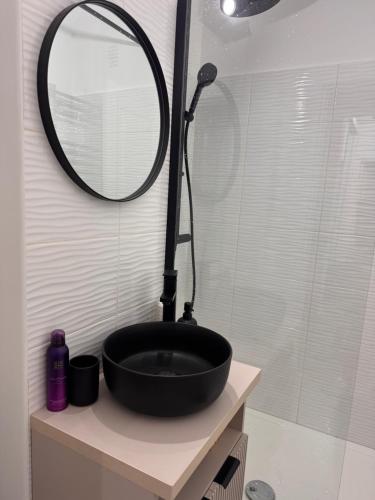 a bathroom with a black sink and a mirror at Olt view apartament in Călimăneşti