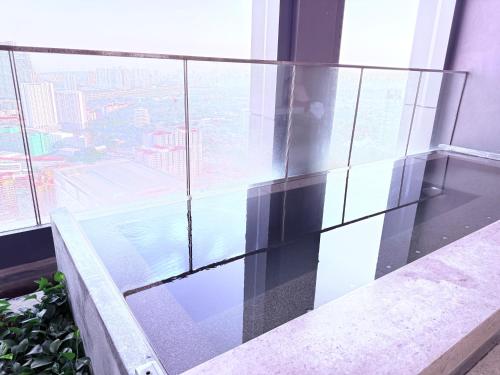 a glass balcony with a view of a city at Lucentia Suites Bukit Bintang Kuala Lumpur in Kuala Lumpur