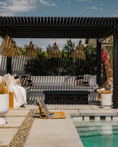 a patio with a pool and chairs and a swimming pool at Indah - Chic Paradise in Coachella Valley in Coachella