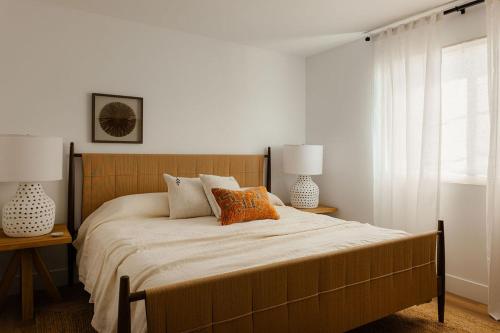 a bedroom with a large bed with two lamps at Indah - Chic Paradise in Coachella Valley in Coachella