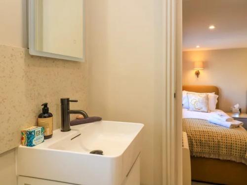 a bathroom with a sink and a bed at Bay House in Broadway