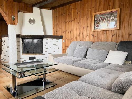 a living room with a couch and a glass table at La Ferme in Barberêche