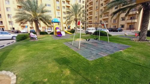 a park with a playground in the middle of a city at Bahria Town Apartment in Karachi