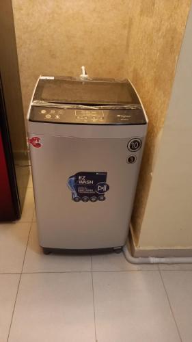 a washing machine sitting on the floor in a room at Bahria Town Apartment in Karachi