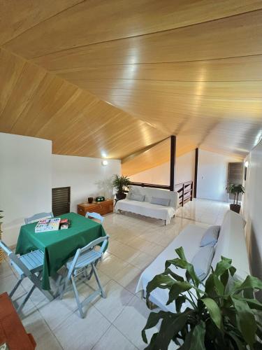 a living room with a green table and a couch at Refugio Brisa do Campo - IG - SOLAR DO CAMPO in Iguaba Grande