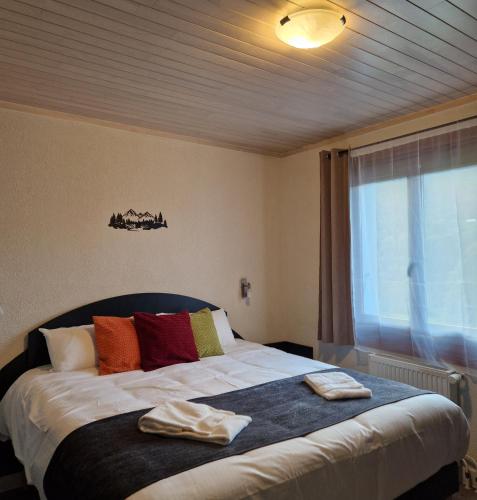 a bedroom with a bed with two towels on it at Hôtel du Centre - Restaurant Lelex'ir in Lélex