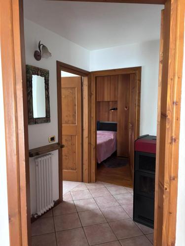 a room with a bedroom with a bed and a mirror at Appartamento Tudaio in Laggio