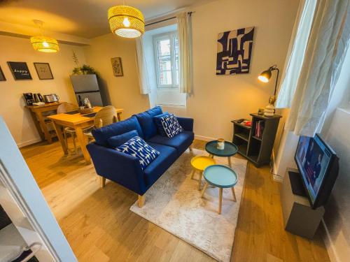 Una sala de estar con un sofá azul y una mesa. en Charmant duplex près du port de Perros-Guirec, en Perros-Guirec
