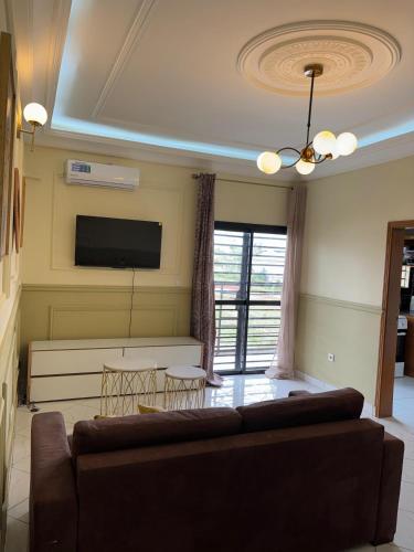 a living room with a couch and a flat screen tv at Résidence Eden in Yaoundé