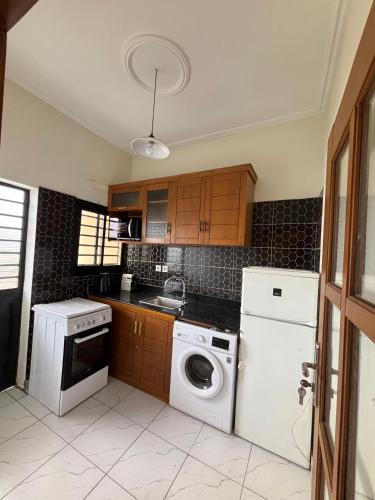a kitchen with a washing machine and a washer at Résidence Eden in Yaoundé