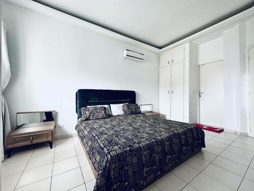 a bedroom with a bed in a white room at CHIC cozy appart bonoumin in Abidjan