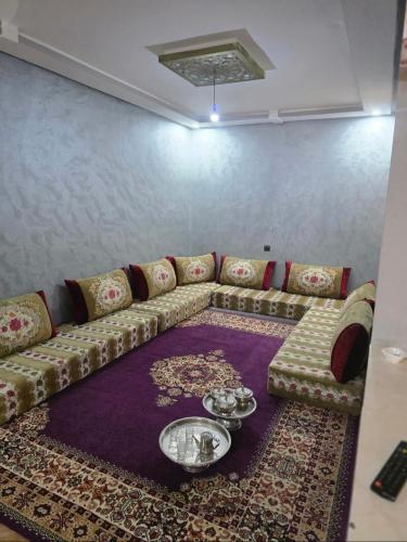 a living room with a couch and a table on a rug at Résidence tarfaya in Tarfaya
