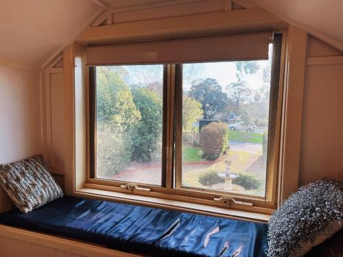 a window in a room with a couch in front of it at 5-Bed Secret Garden House in Croydon