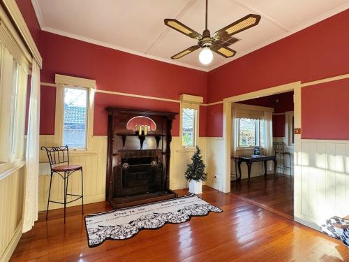 a living room with red walls and a fireplace at 5-Bed Secret Garden House in Croydon