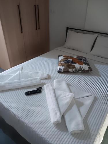 a white bed with towels and a pen on it at Melodia Lefkada apartment 1 in Nikiana