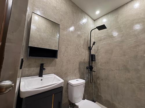 a bathroom with a toilet and a sink and a shower at Solana Inn El Nido in El Nido