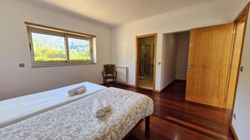 ein Schlafzimmer mit einem Bett und einem Fenster in der Unterkunft Quintela Village by Gerês Casas in Terras de Bouro
