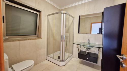 ein Badezimmer mit Glasdusche und Waschbecken in der Unterkunft Quintela Village by Gerês Casas in Terras de Bouro