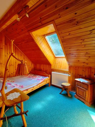 a bedroom with a bed and a window in a cabin at Karczma Starożyn in Płaska