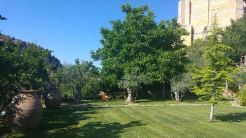 a yard with trees and a large building at La Casa del Cura de Calatañazor in Calatañazor