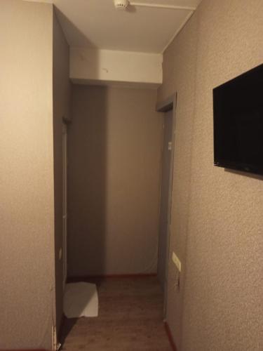 an empty hallway with a flat screen tv on a wall at კაველა 555 in Tbilisi City