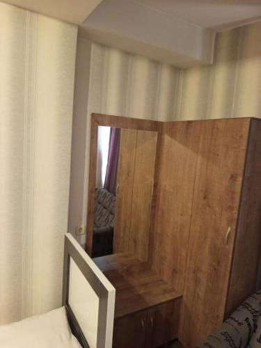 a bedroom with a wooden door and a mirror at კაველა 555 in Tbilisi City