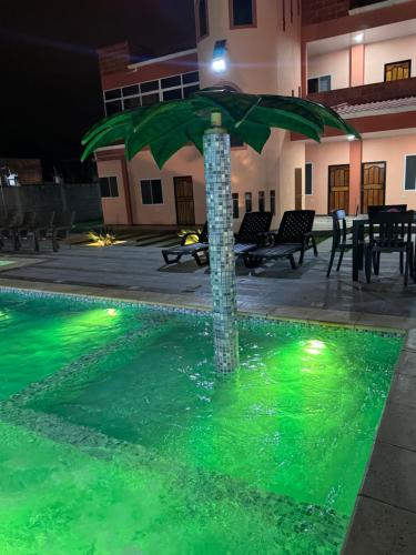 an umbrella in the middle of a pool at night at BeachClub Tonsupa by Cascada Spa Ecuador in Tonsupa