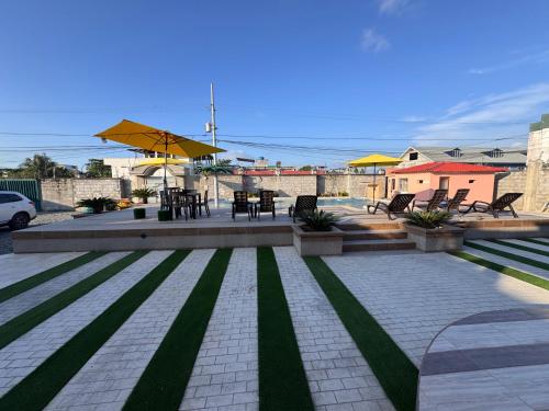 a patio with tables and chairs and a table and chairs at BeachClub Tonsupa by Cascada Spa Ecuador in Tonsupa