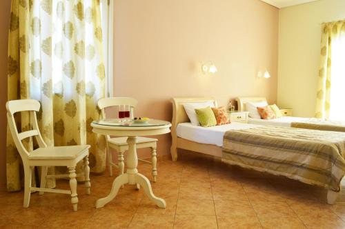 1 dormitorio con 2 camas, mesa y silla en Kalia Studios, en Agia Anna de Naxos