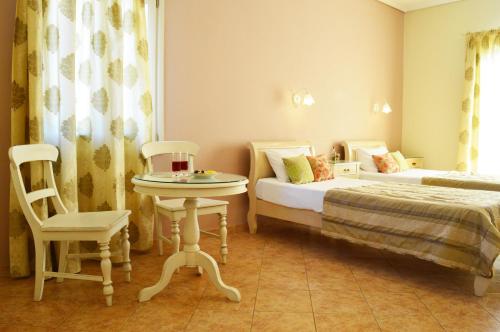 ein Schlafzimmer mit zwei Betten, einem Tisch und einem Stuhl in der Unterkunft Kalia Studios in Agia Anna