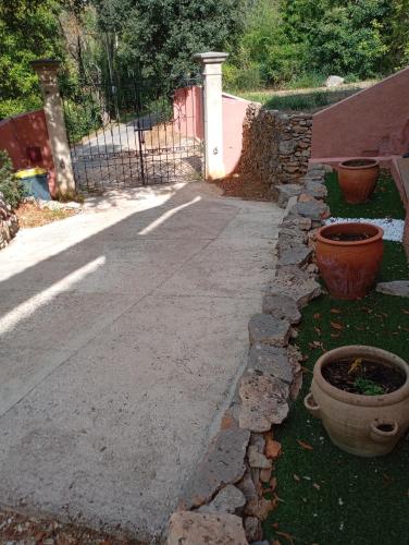 a walkway with some pots and a fence at Chez Dominique et Jean-Louis - Logement T2 50m2 in Tourves
