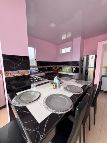 a kitchen with purple walls and a table with plates on it at BeachClub Tonsupa by Cascada Spa Ecuador in Tonsupa