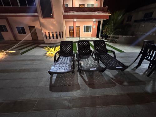 two black benches sitting on a patio at night at BeachClub Tonsupa by Cascada Spa Ecuador in Tonsupa