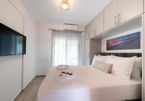 a bedroom with a large white bed with two towels at Melodia Lefkada apartment 5 in Nikiana
