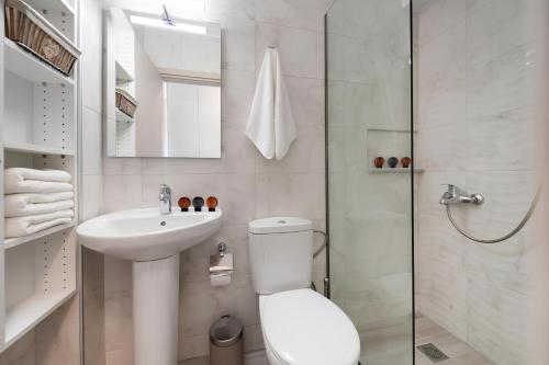 a bathroom with a toilet and a sink and a shower at Melodia Lefkada apartment 5 in Nikiana