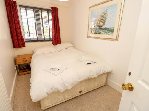 a bedroom with a bed with white sheets and a window at Riverview in Hamble