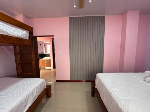 two beds in a room with pink walls at BeachClub Tonsupa by Cascada Spa Ecuador in Tonsupa
