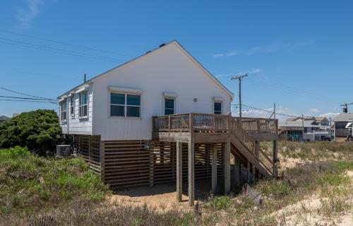 a white house with a deck on the beach at Mitch's Haven in Kitty Hawk