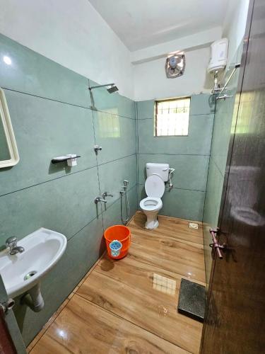 a bathroom with a toilet and a sink at Harichandhanam Inn - Entire Flat, Ground Floor, 200m From East Nada Guruvayur in Guruvāyūr