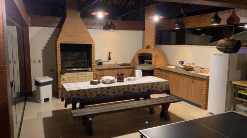 a large kitchen with a table and an oven at Casa Campos do Jordão, bairro Capivari, Wi-Fi, churrasqueira e forno de pizza, totalmente equipada in Campos do Jordão