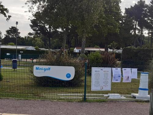 a fence with signs on it in a park at Très beau Mobil Home 40 m2 3Ch - Camping 4 étoiles Les Charmettes 370- proche FUN ZONE in Les Mathes